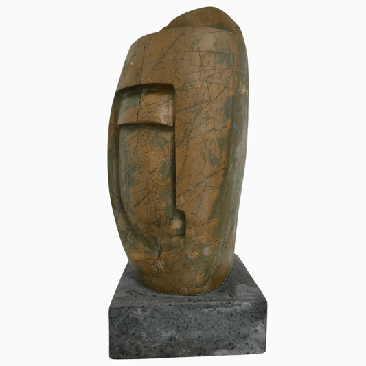 Scultura astratta in pietra naturale marrone e verde scuro su tavolo moderno.