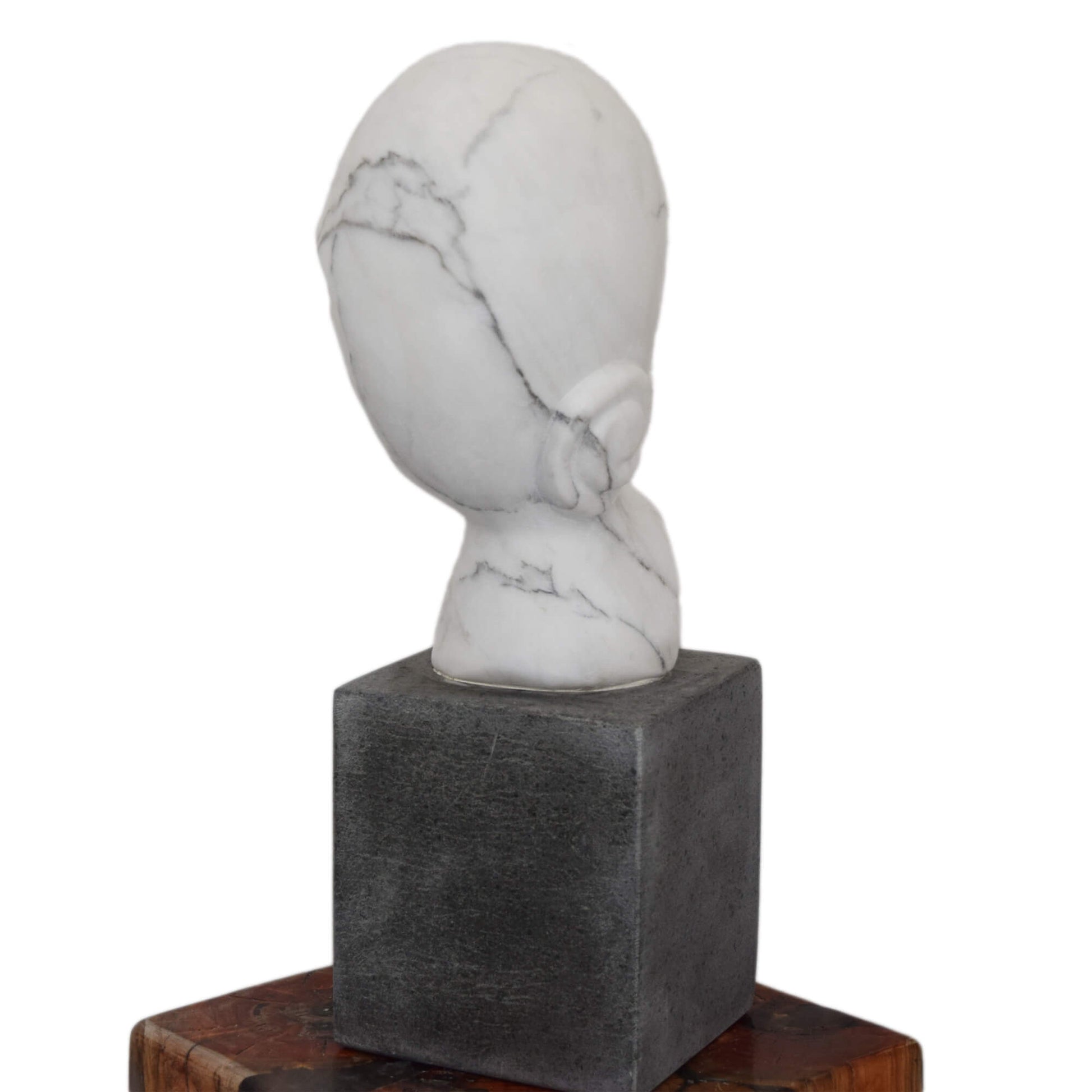 Testa scolpita a mano in marmo bianco con base in pietra vulcanica

